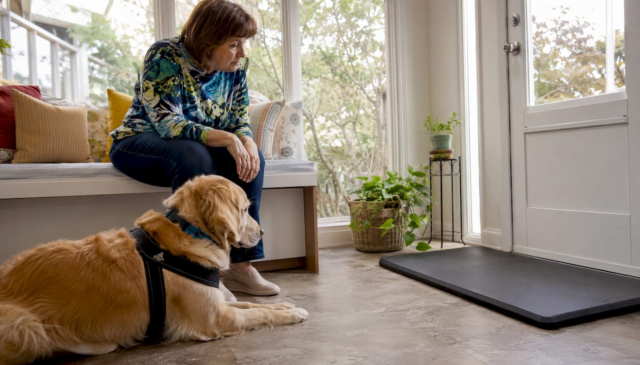 Woman and service dog using home pet alert system